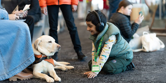 Small child sitting with Facilities dog
