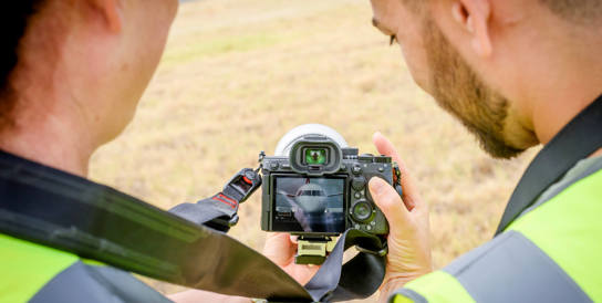 Two people looking at their camera screen 