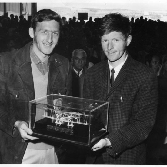 two men holding plane trophy