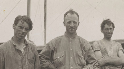 Three men standing in a row