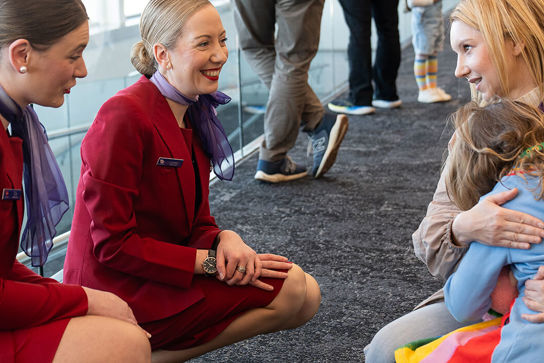 airline staff look at small child hugging mum