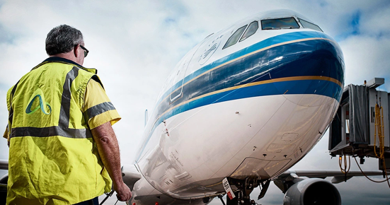 Adelaide Airport Employee standing in front of a plane